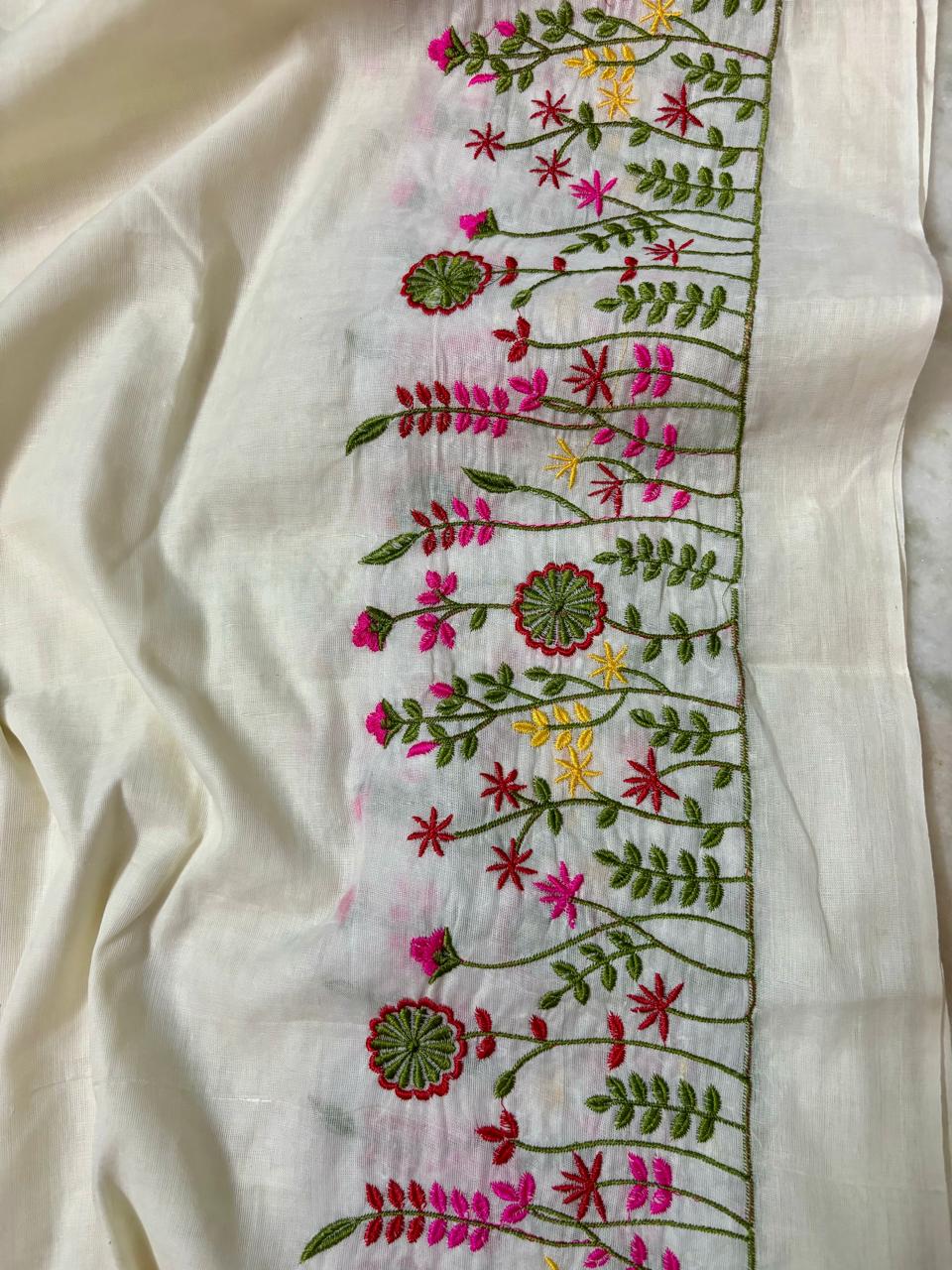 An off-white or cream-colored fabric panel featuring a vertical border of colorful floral embroidery in pink, red, yellow, and green.
