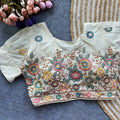 Embroidered blouse with floral patterns on a textured surface