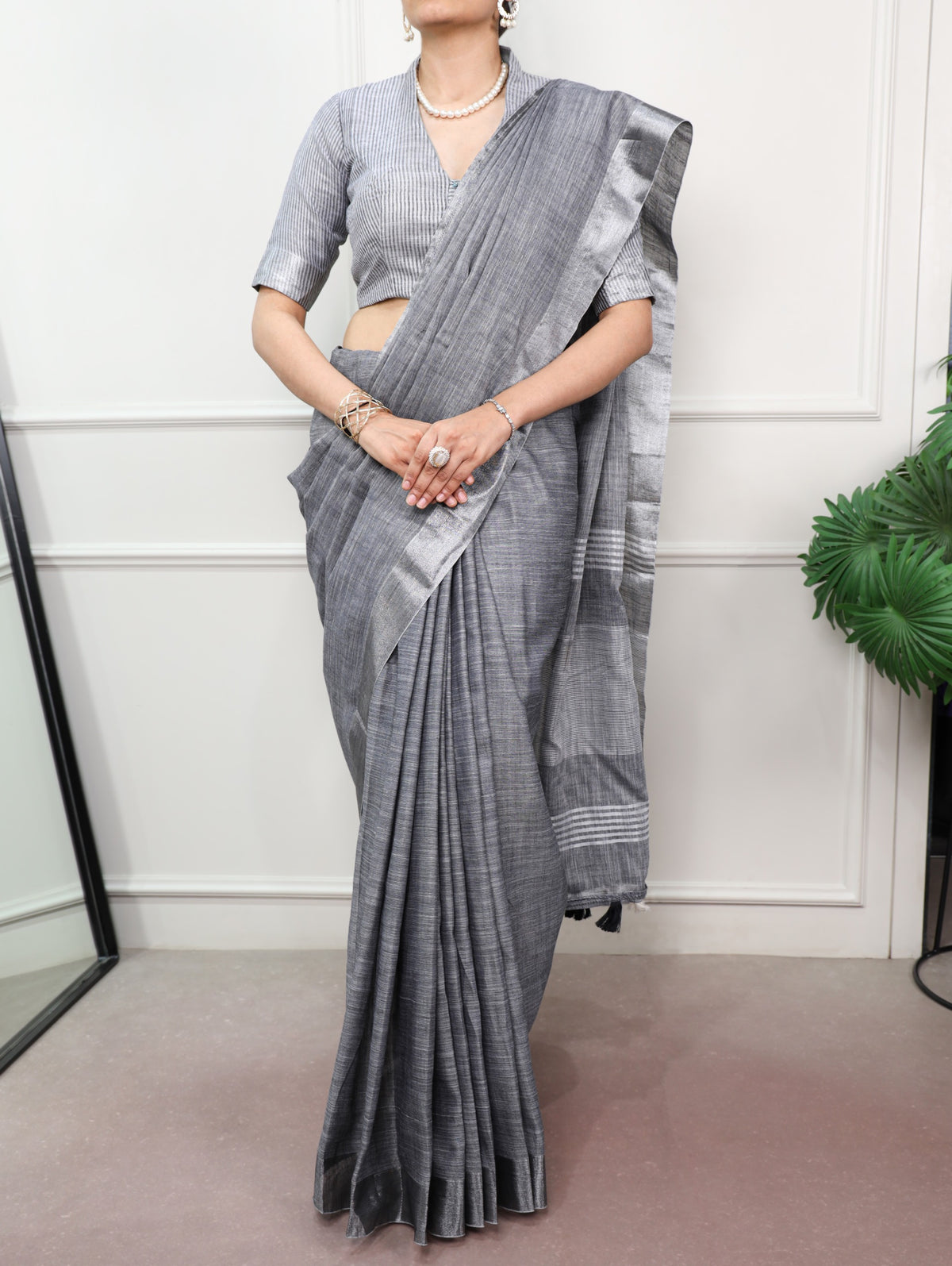 women wearing a gray linen saree with a white background