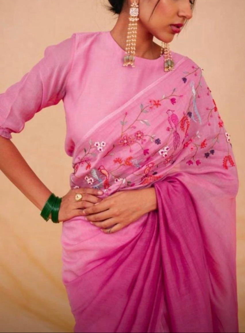 Woman wearing a pink ombré linen saree with embroidered birds and flowers on the pallu
